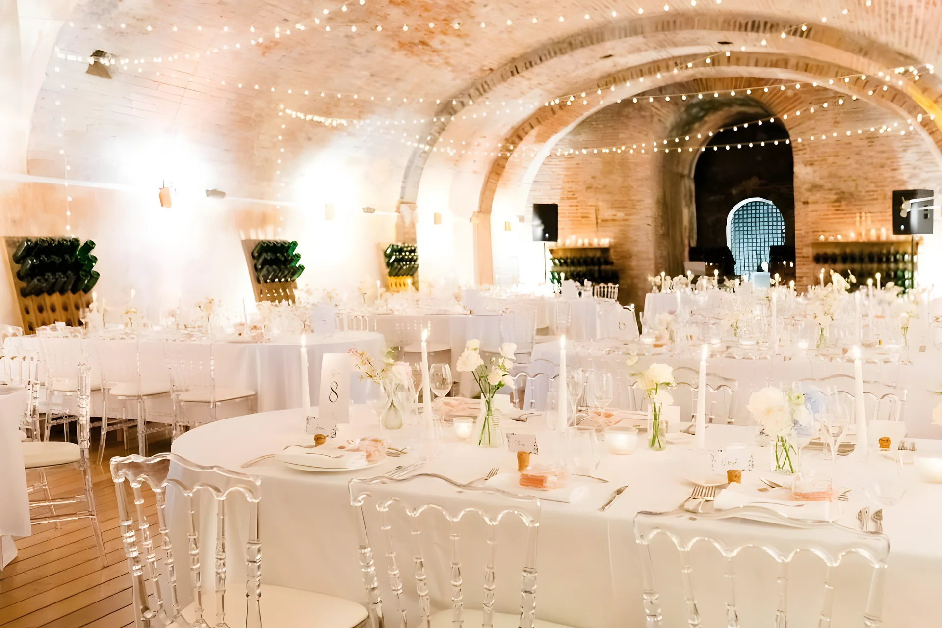 Dinner tables laid under the lit brick vaults of the cellar